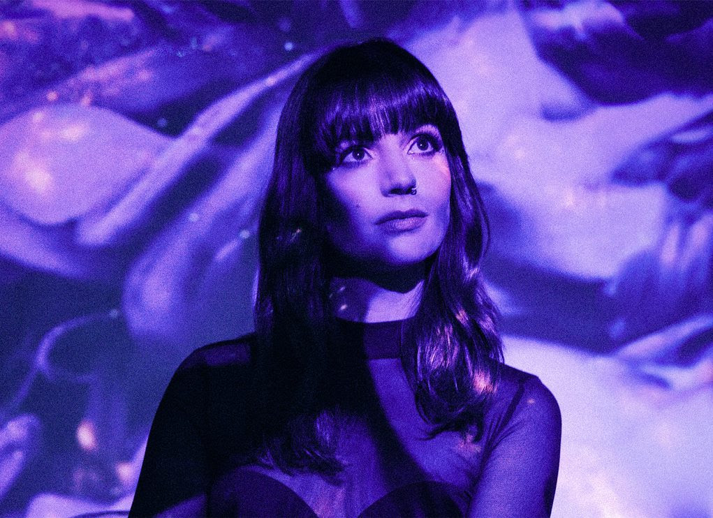 Anna Smyrk stood against a purple background.