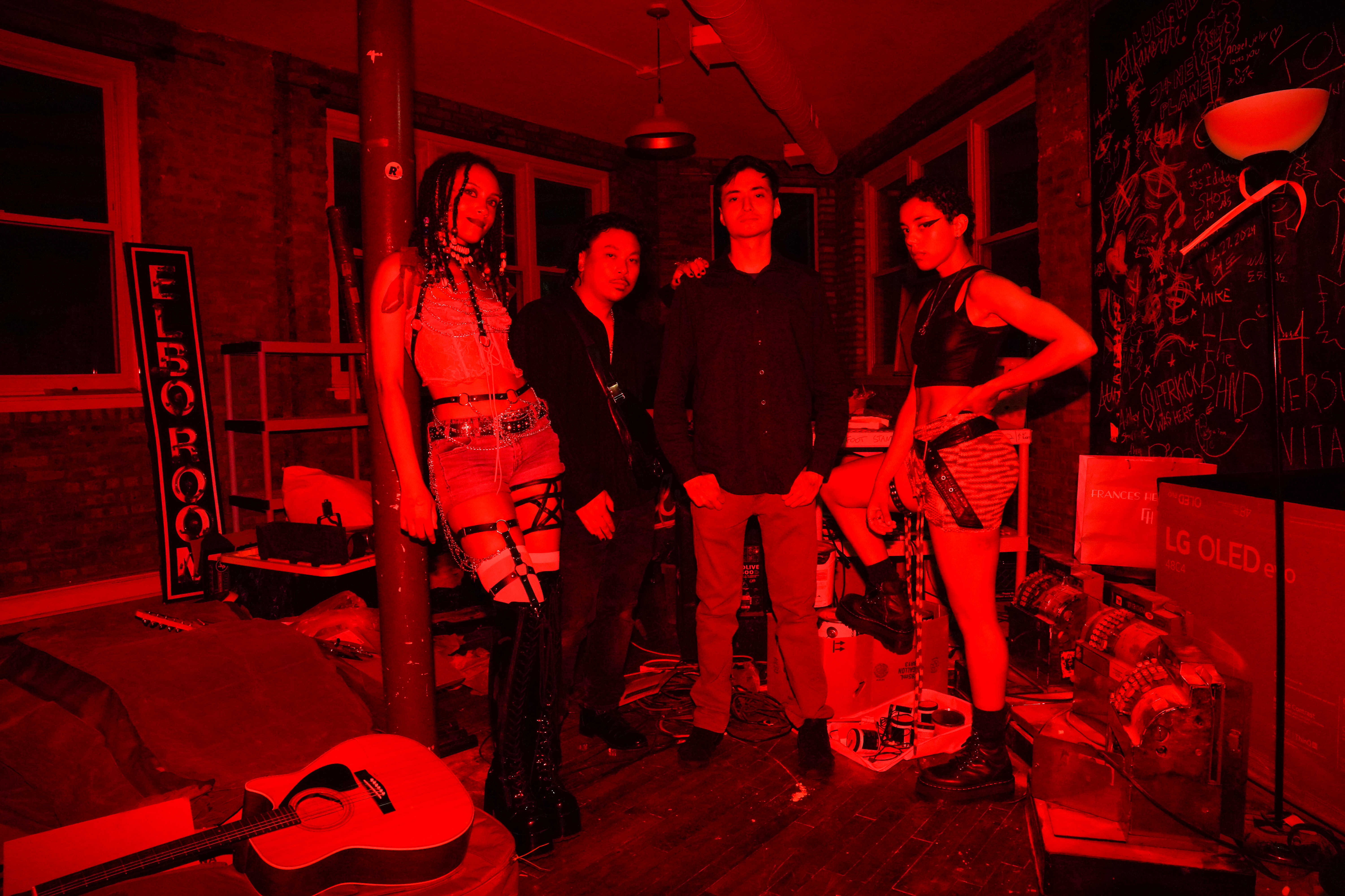 black and red landscape tinted photo of the four members of Faerie Dream