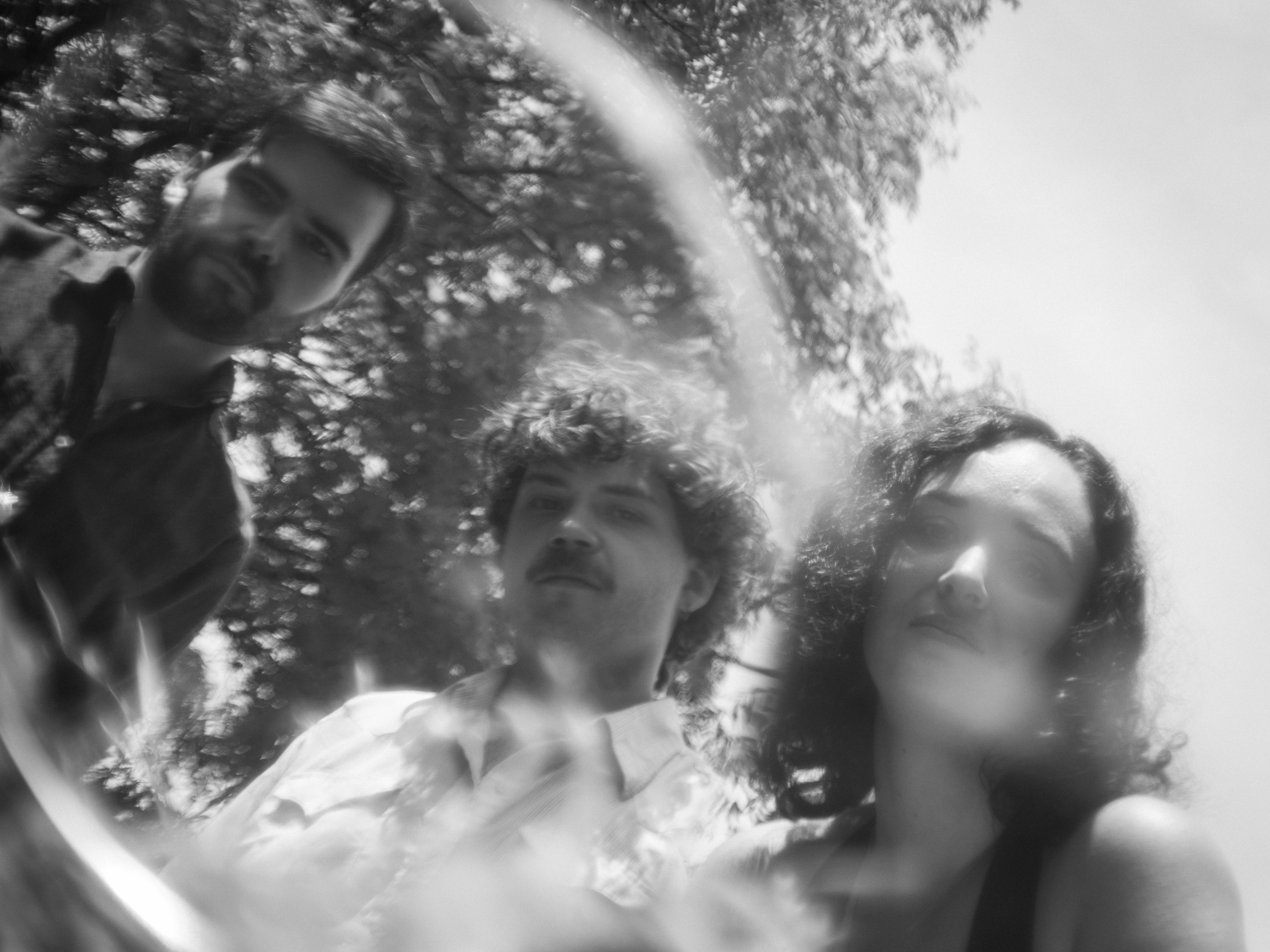 Blurry black and white outdoor photo of the band Shapeshifter.